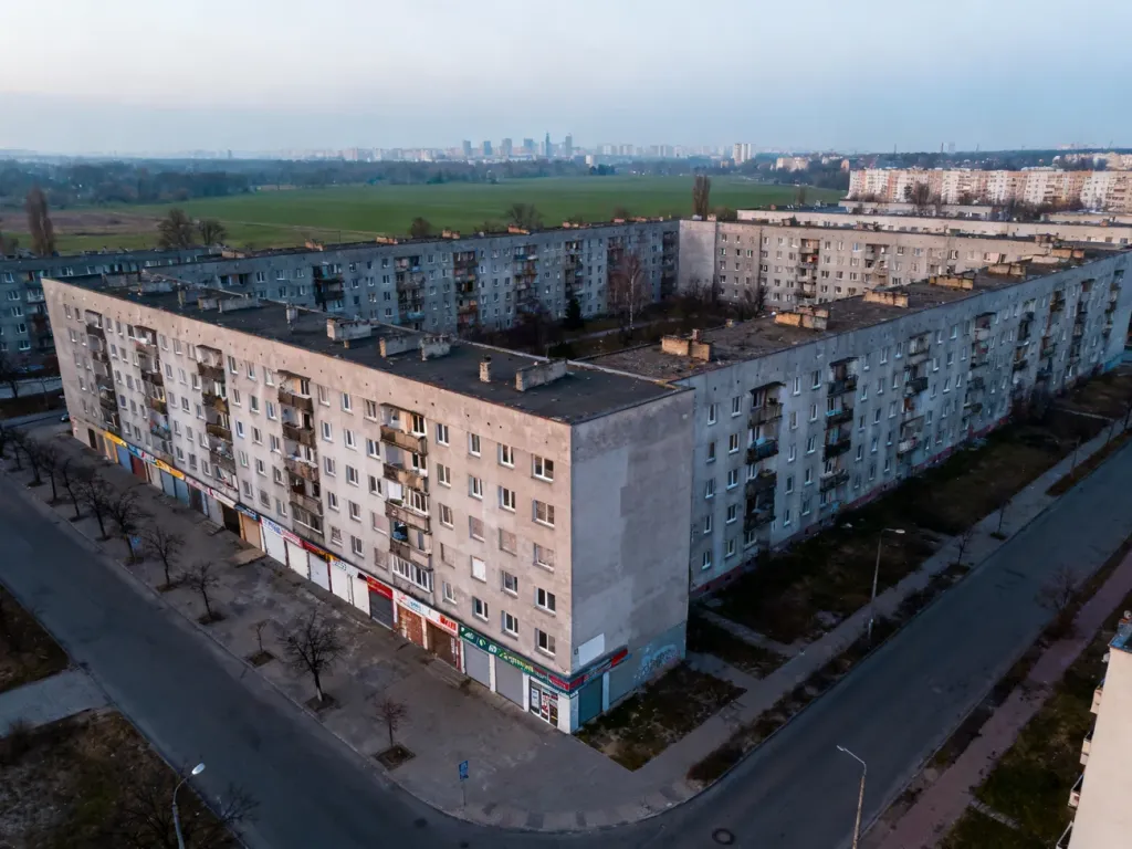 Widok z lotu ptaka na opustoszałe polskie miasto z pustymi blokowiskami i zamkniętymi lokalami usługowymi.